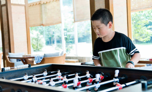 istock Boy playing foosball in games room 1292260551