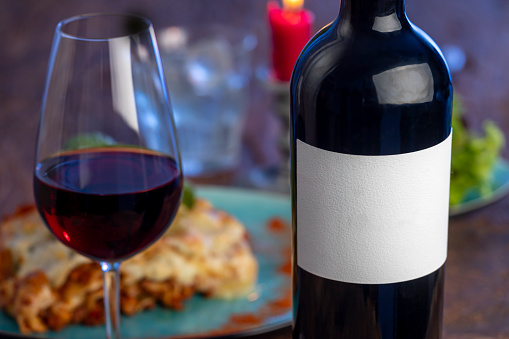 wine bottle and lasagna on wood