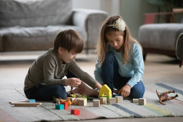 istock Small children sit at home play with bricks together 1292260700
