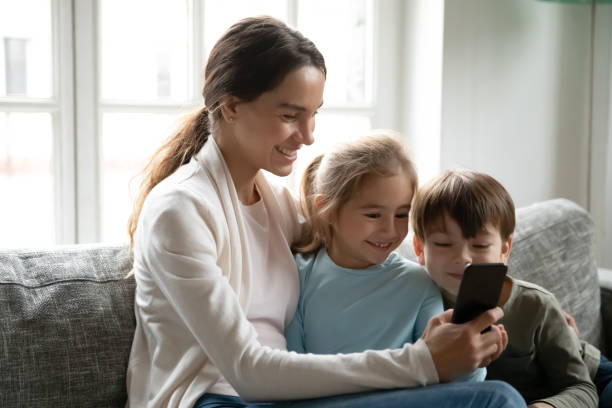 istock Smiling mother and little kid use cellphone together 1292260710