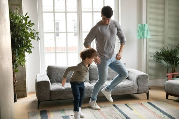 istock Happy father dancing with excited little son at home 1292260717