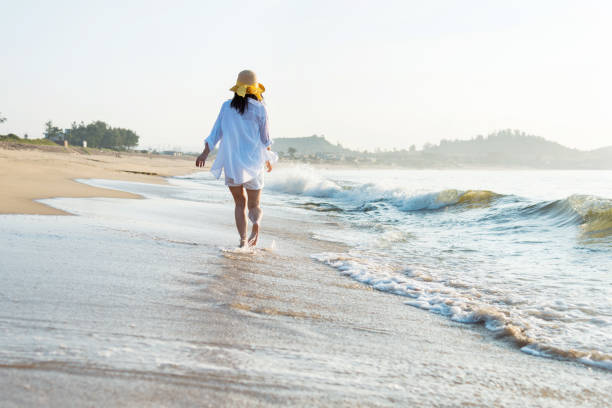istock Woman walking on the beach 1292261113