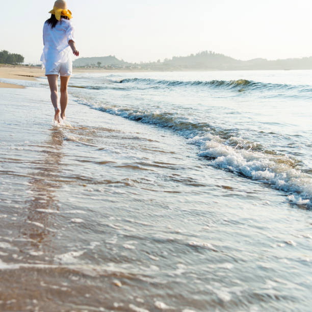 istock Woman walking on the beach 1292261188