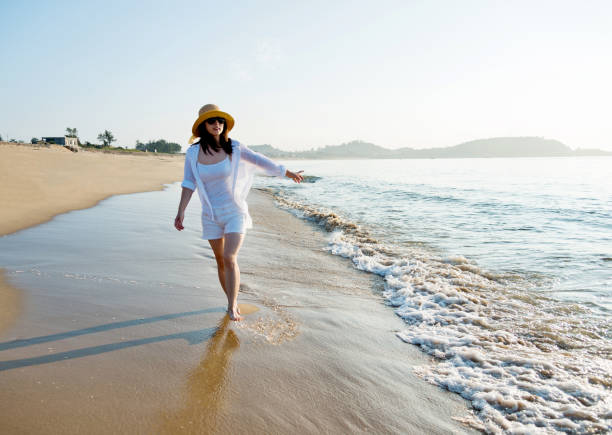 istock Happy woman walking on the beach 1292261269