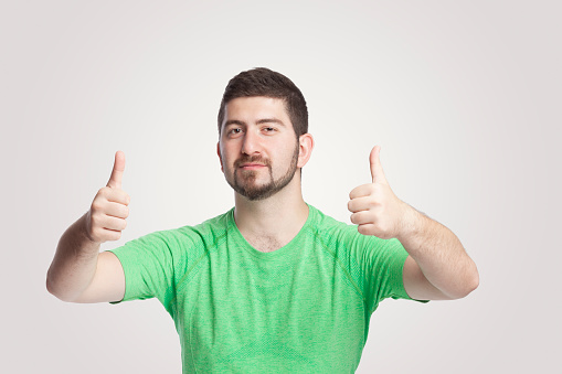 Portrait of handsome man giving thumbs up with both hands over white background.Handsome man giving thumbs up gesture over white background