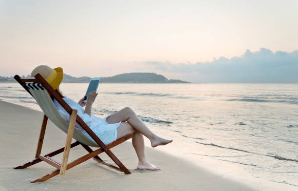 istock Woman using digital tablet at the beach 1292262037