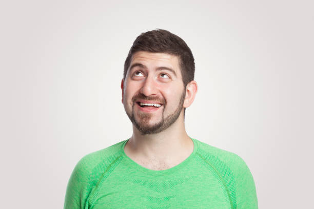 istock Thoughtful young man looking up over white background 1292262179