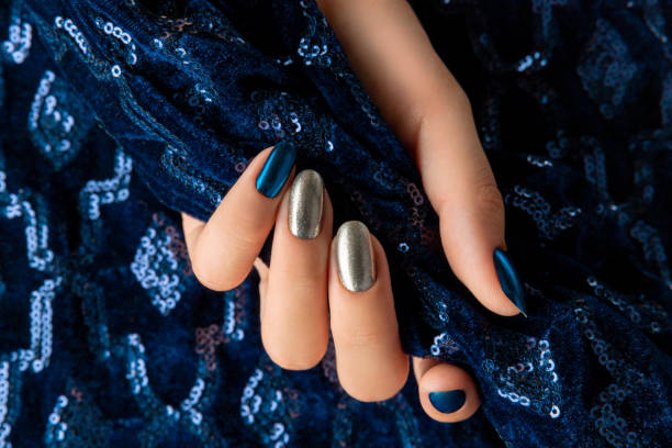 istock Womans hand with manicure on the creative blue sparkle background. 1292262357