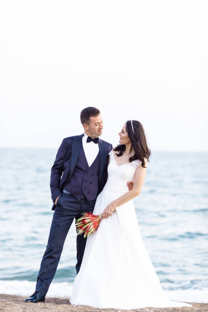 Romantic newlywed young couple embracing on beach