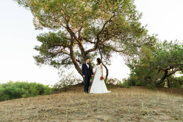 Newly wed couple with flower bouquet in park