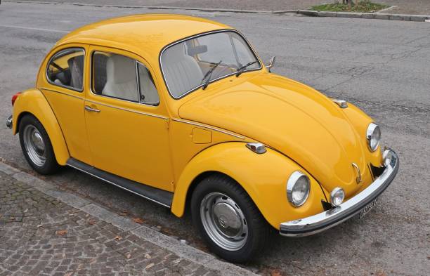 żółty volkswagen beetle zaparkowany na poboczu drogi. - engine obsolete old retro revival zdjęcia i obrazy z banku zdjęć