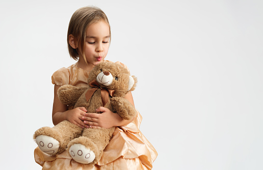 Portrait Of A Charming Little Girl With Soft Toy Bear