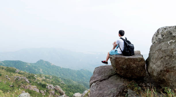 istock Man backpacker sitting on the top of mountain 1292265668