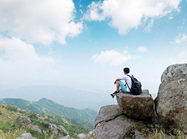 istock Man backpacker sitting on the top of mountain 1292266620