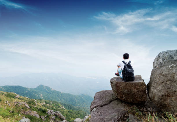 istock Man backpacker sitting on the top of mountain 1292267441
