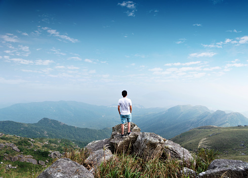 Man standing on the top of mountain.