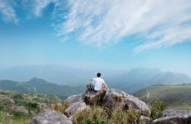 istock Man sitting on the top of mountain 1292267683