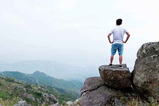 Man standing on the top of mountain.
