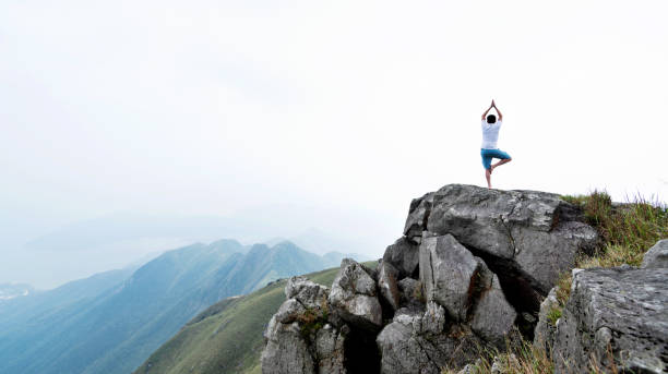 istock Man doing yoga on top of mountain 1292268465