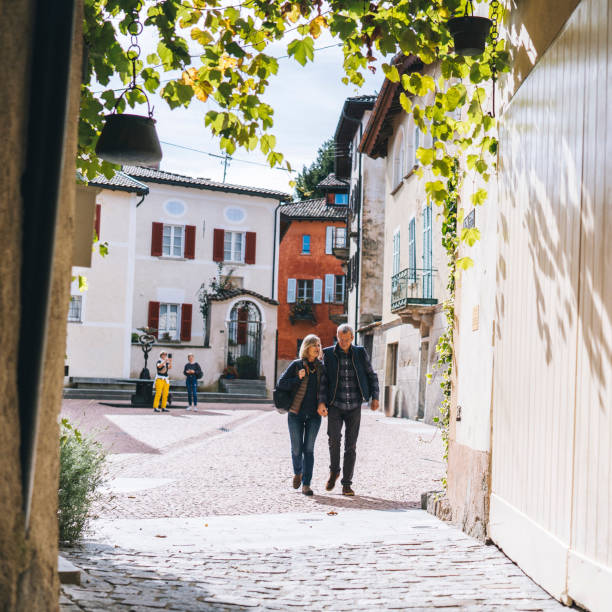 istock Mature couple walk through sunny European piazza 1292269131