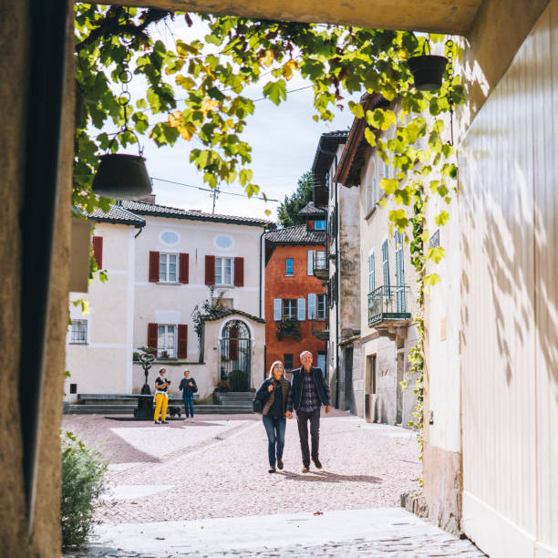 istock Mature couple walk through sunny European piazza 1292270838