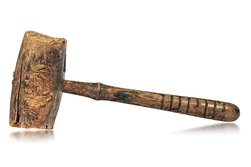 Closeup of an old wooden mallet or hammer, made in Italy, 19th century. Isolated on white background with reflections.