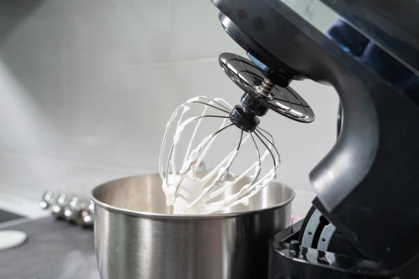 open black Electric stand mixer on a table in the kitchen with white cream open black Electric stand mixer on a table in the kitchen with white cream electric mixer photos stock pictures, royalty-free photos & images