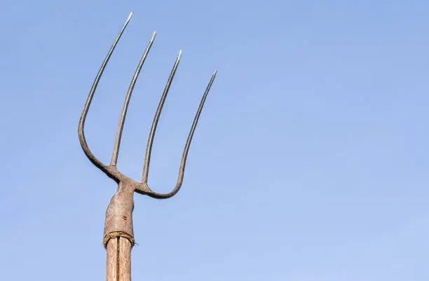 Pitchfork raised to the sky, close-up. Weapons of the proletariat.