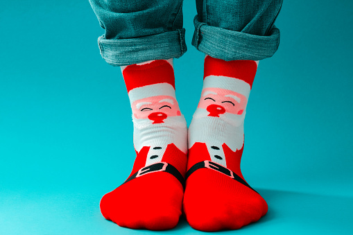 male legs in red  Christmas funny socks on a blue background