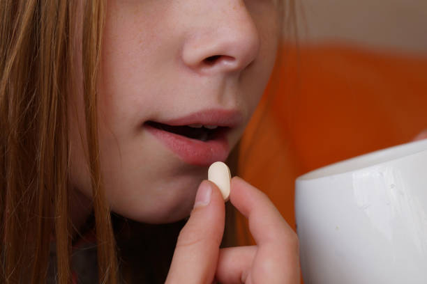 istock a girl takes a pill close up 1292278141