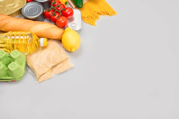 istock Flat lay composition with food donations on grey background with copyspace - pasta, fresh vegatables, canned food, baguette, cooking oil. Food donations and food bank concept 1292279051