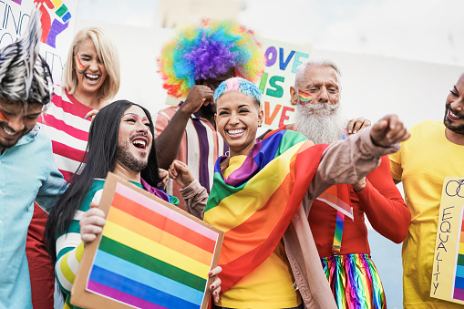 Personas de diferentes generaciones se divierten en el desfile del orgullo gay con estandarte - concepto de amor lgbt y homosexual photo