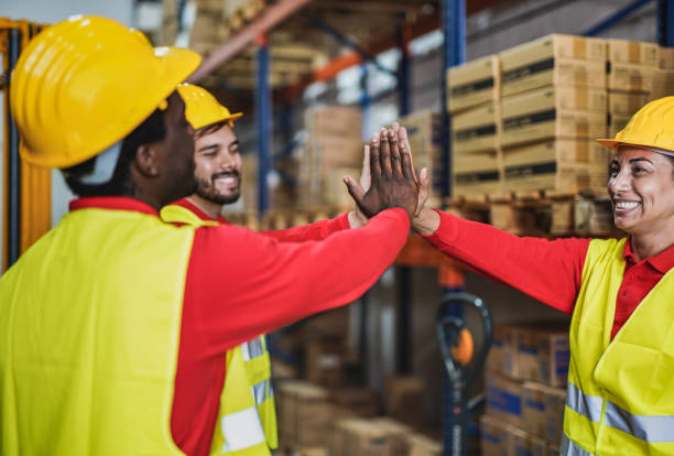 istock Warehouse workers giving high five to each othee - Industrial multiracial people with hands together for success and teamwork 1292280266