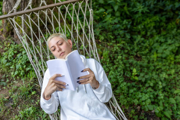 istock Woman reading a book in hammock 1292281039
