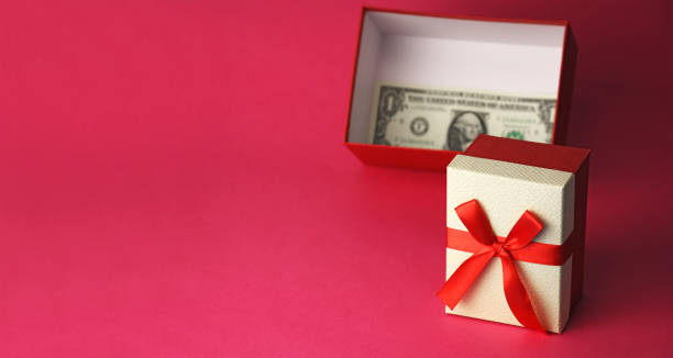 istock open gift box with money cash note, blurred one dollar bill, on pink background, copy space 1292281212