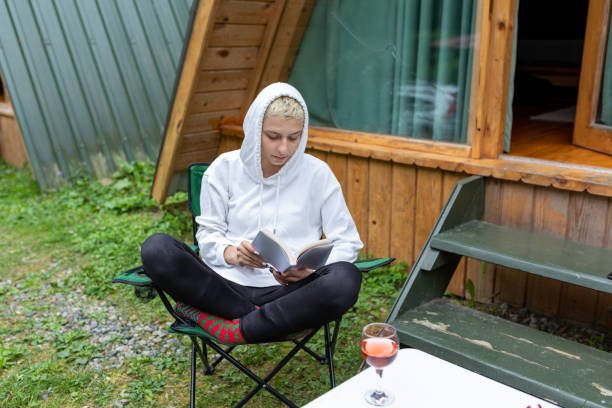 istock Woman reading book outside her house 1292283245