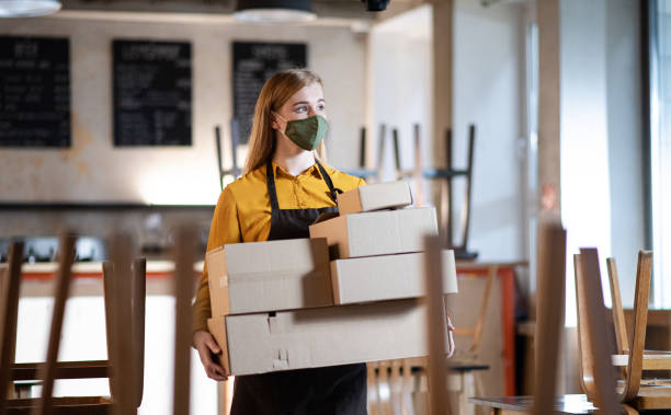 istock Frustrated owner carrying boxes in closed cafe, small business lockdown due to coronavirus. 1292283401