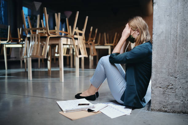 Tired owner sitting on floor in closed cafe, small business lockdown due to coronavirus. Tired woman owner sitting on floor in closed cafe, small business lockdown due to coronavirus. bankruptcy stock pictures, royalty-free photos & images