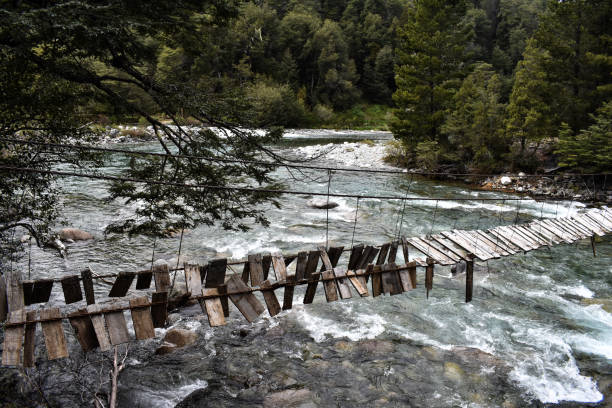 istock Wooden bridge broken in river with rocks 1292284934