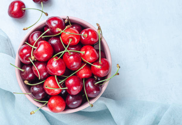 istock Cherry with leaf on plate and water dropsand on grey stone table 1292285821