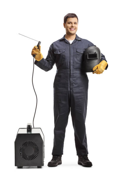 full length portrait of a welder in a uniform with a welding generator and a protective helmet - manual worker portrait helmet technology imagens e fotografias de stock
