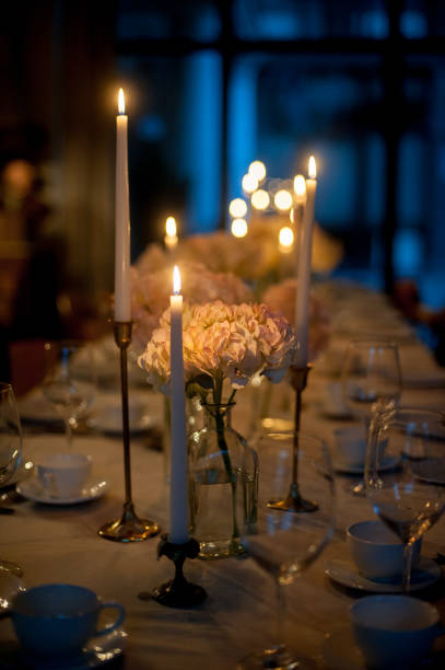 istock New Year table served for a romantic festive dinner. Christmas setting on white table with decoration flowers plates and wine glasses and candles 1292289594