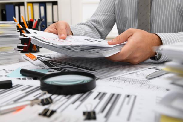 istock business concept - businessman working with reports in office, table and workspace close view, analyzing financial data, writes and counts 1292290227