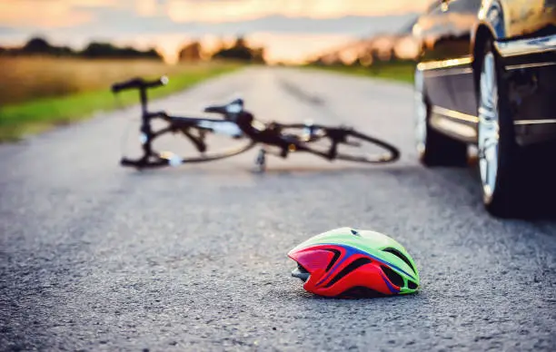 Traffic accident. Bicycle and helmet on the road after a car hit a cyclist