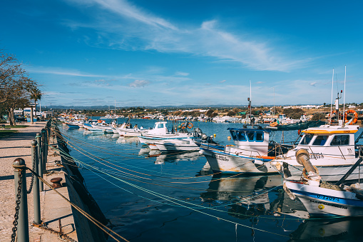 colorful boats in the sun \nFuseta harbor in the Algarve in the south of Portugal in Europe