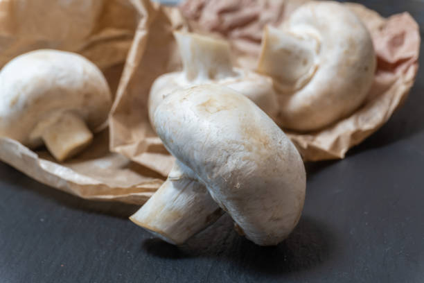 istock Fresh white mushrooms on recycled paper 1292293054