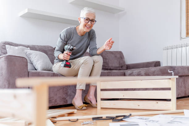 istock Mature woman installing bookcase. 1292295023