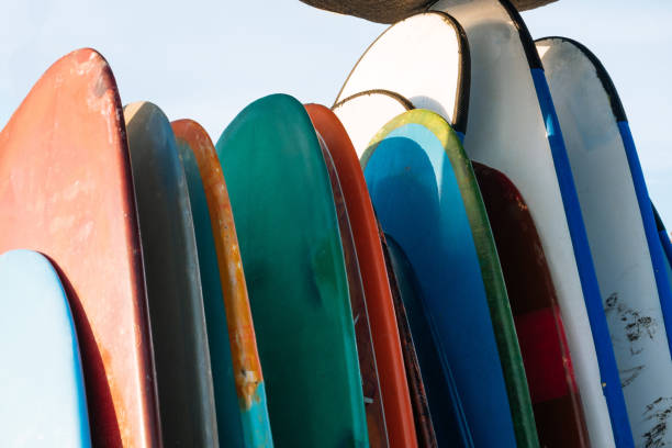 istock Set of different color surf boards in a stack by ocean.Bali.Indonesia. Surf boards on sandy beach for rent. Surf lessons on Weligama beach, Sri Lanka. 1292296025