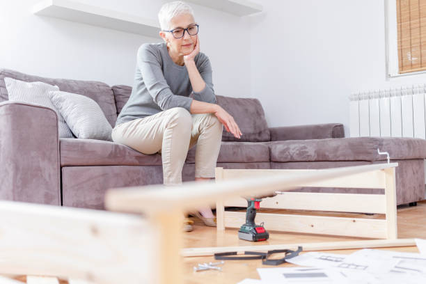 istock Mature woman installing bookcase. 1292296211
