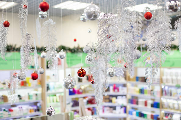 Christmas decorations: Christmas balls, tinsel branches in cosmetic shop. Blurred shelves with skin and hair care products in a cosmetic store as background stock photo